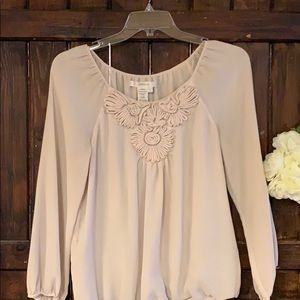 A beautiful cream colored blouse with detailing